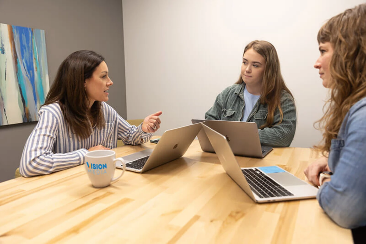 Megan, Brooke and Erika sitting at a meeting table.