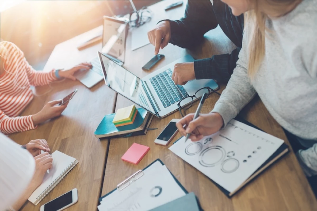 Image of people at a table working.