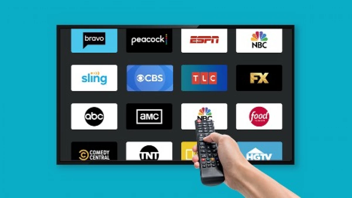 hand holding a remote control pointed at a screen with many streaming logos