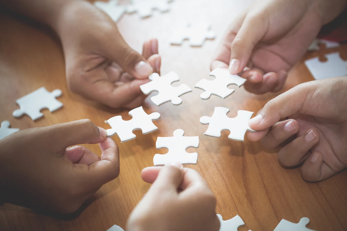 People putting their puzzle pieces together in collaboration