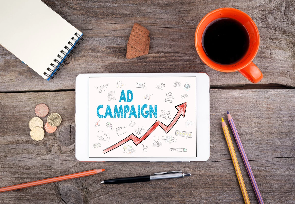 desktop with laptop showing ad campaign sketch