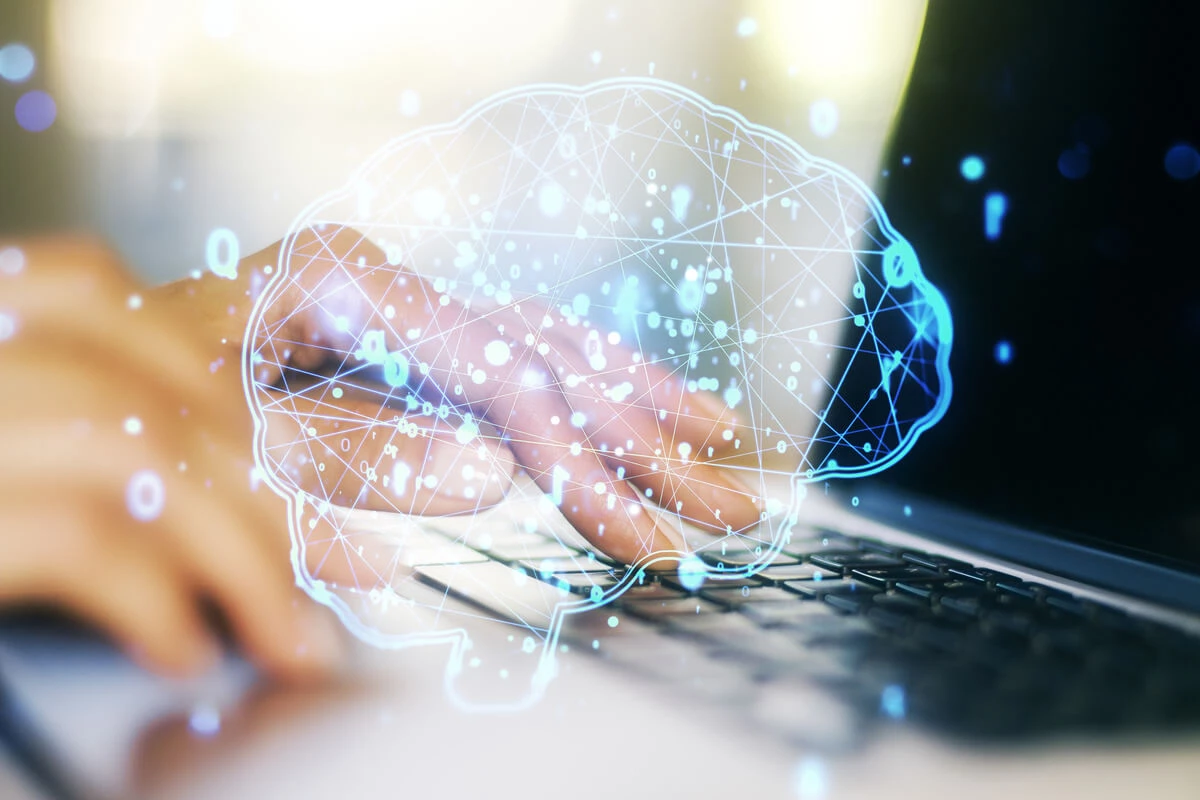 hands on keyboard with digital brain image floating above